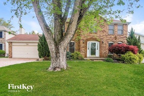 A brick house with a tree in front of it.