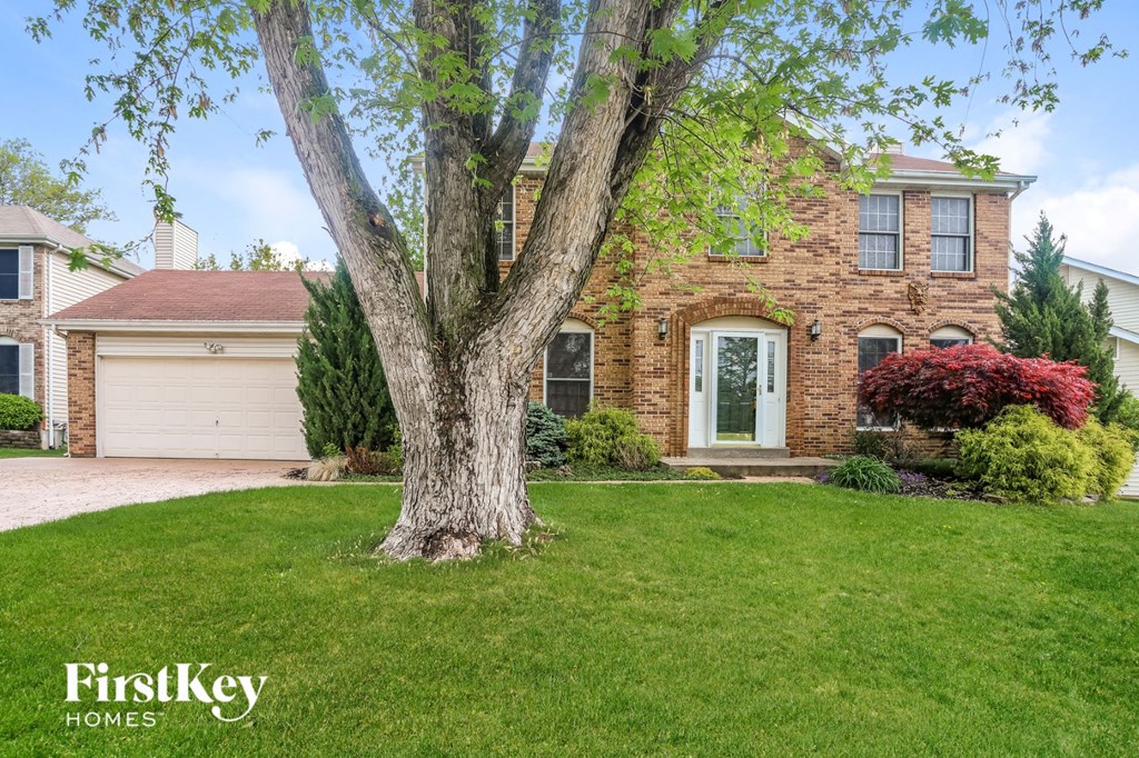 A brick house with a tree in front of it.