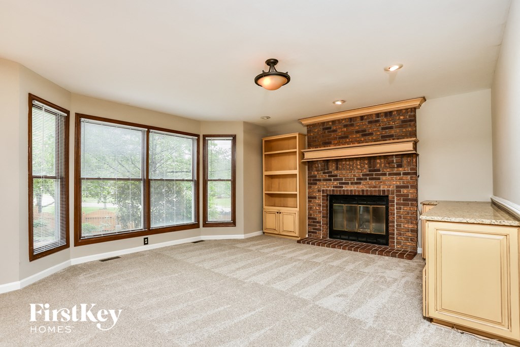 A living room with a fireplace and a large window.