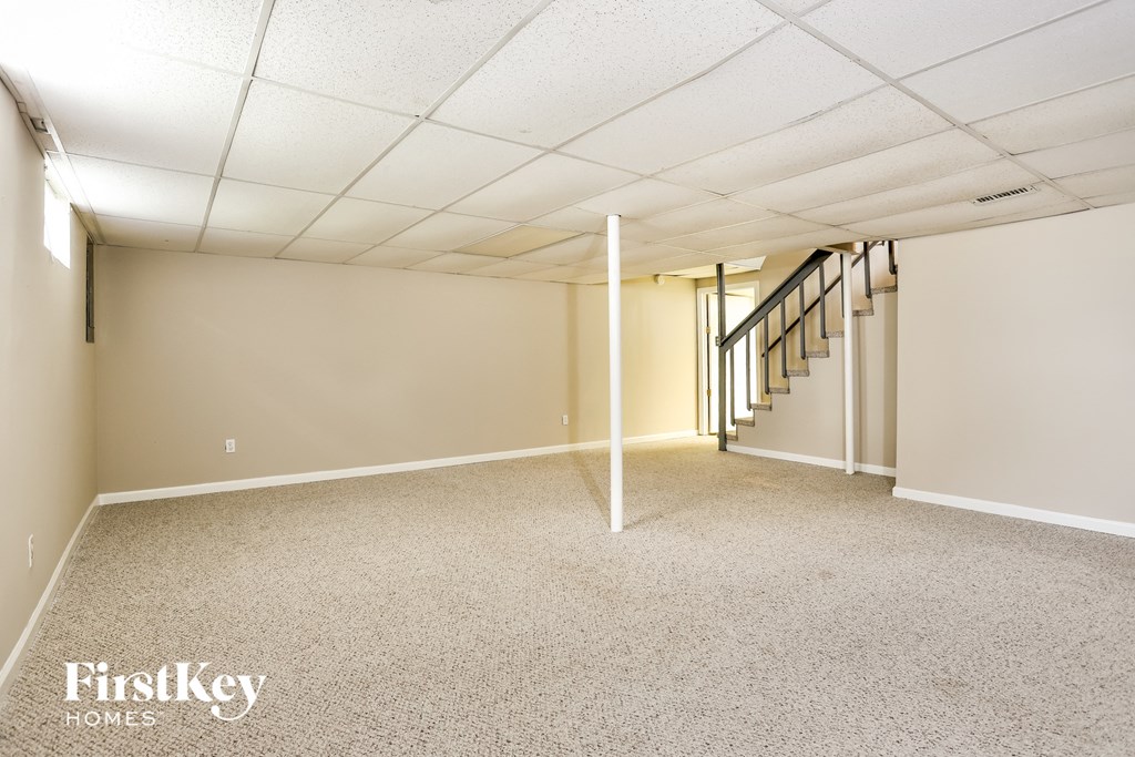 A spacious room with a staircase leading to another room.