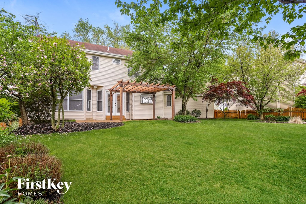 A house with a well-kept lawn and trees in the background.