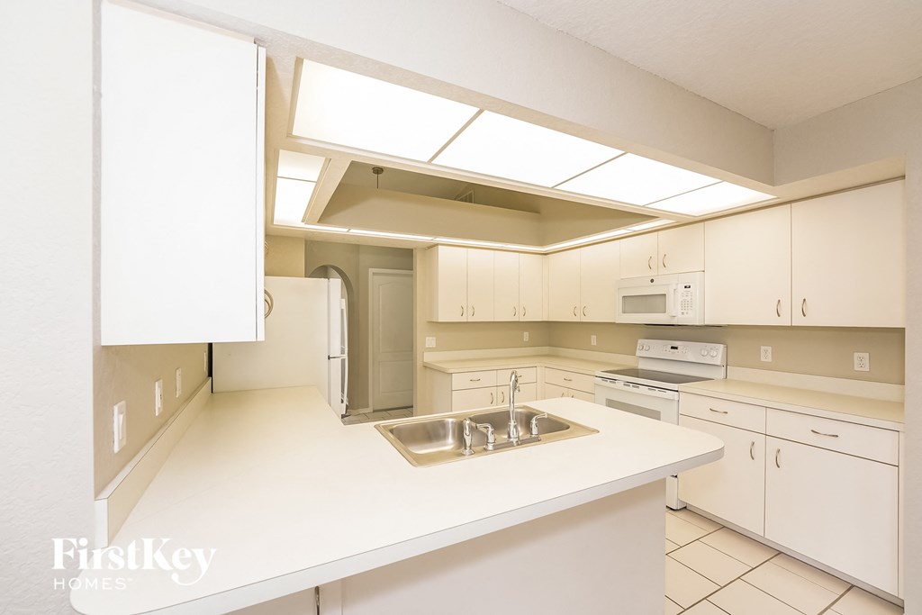 a kitchen with white cabinets and a sink