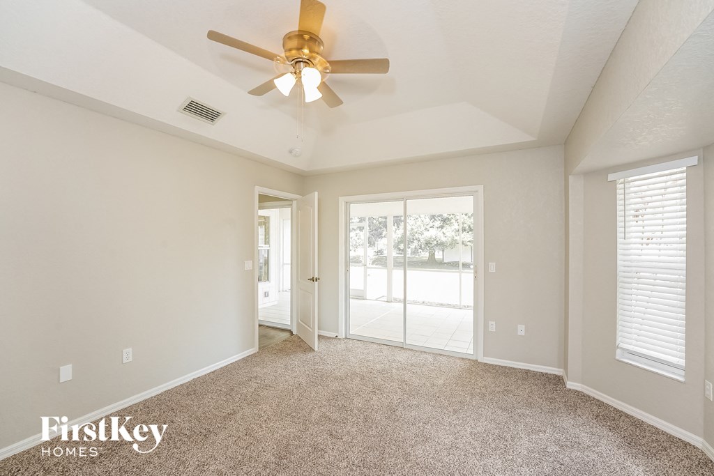 the living room of an empty house with a ceiling fan