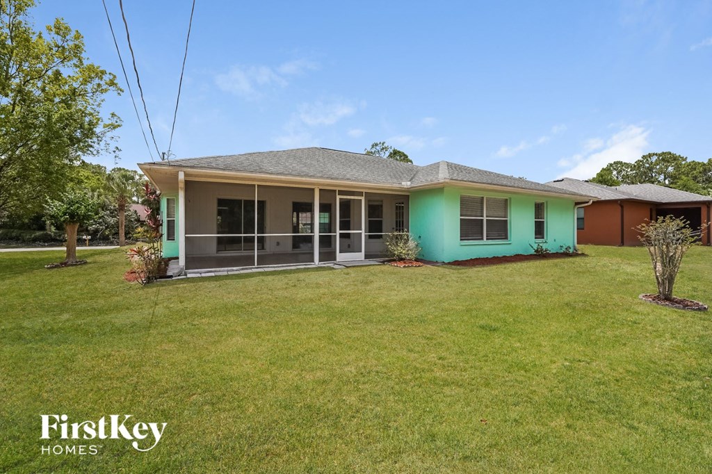 a green house with a lawn and a porch