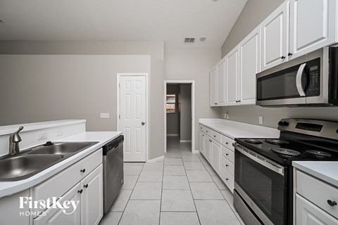 a kitchen with white cabinets and black appliances