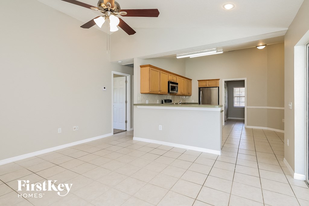an empty kitchen and living room with a ceiling fan