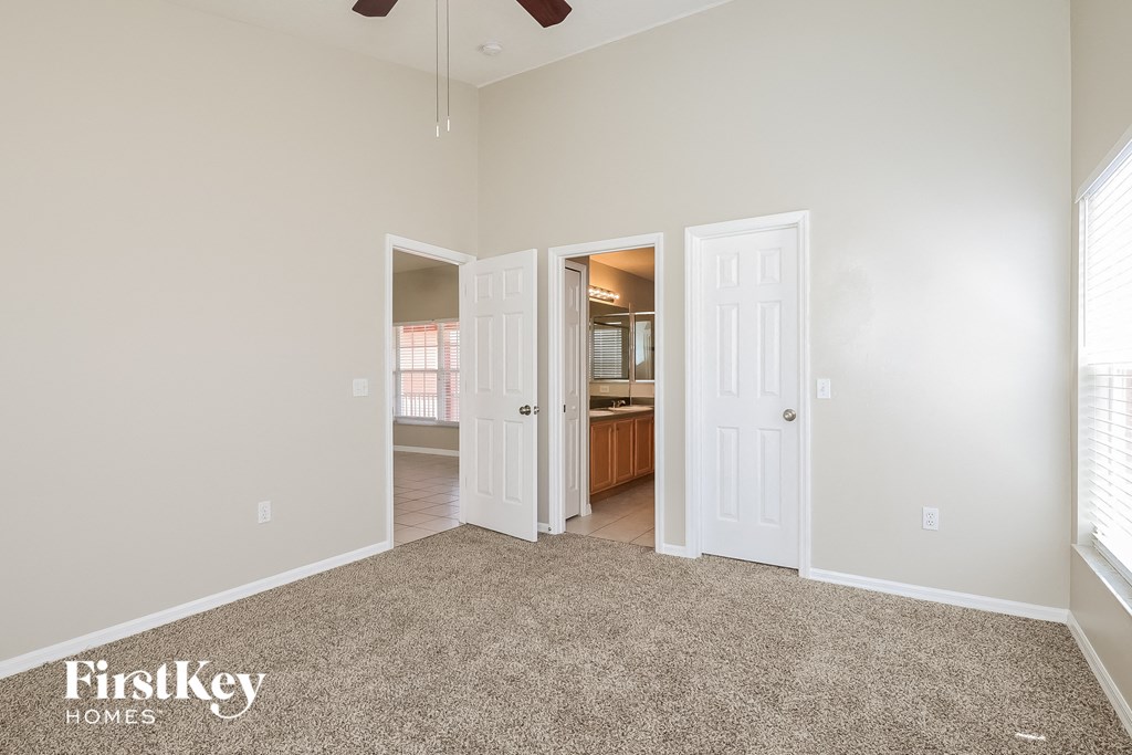 a living room with carpet and a door to a kitchen