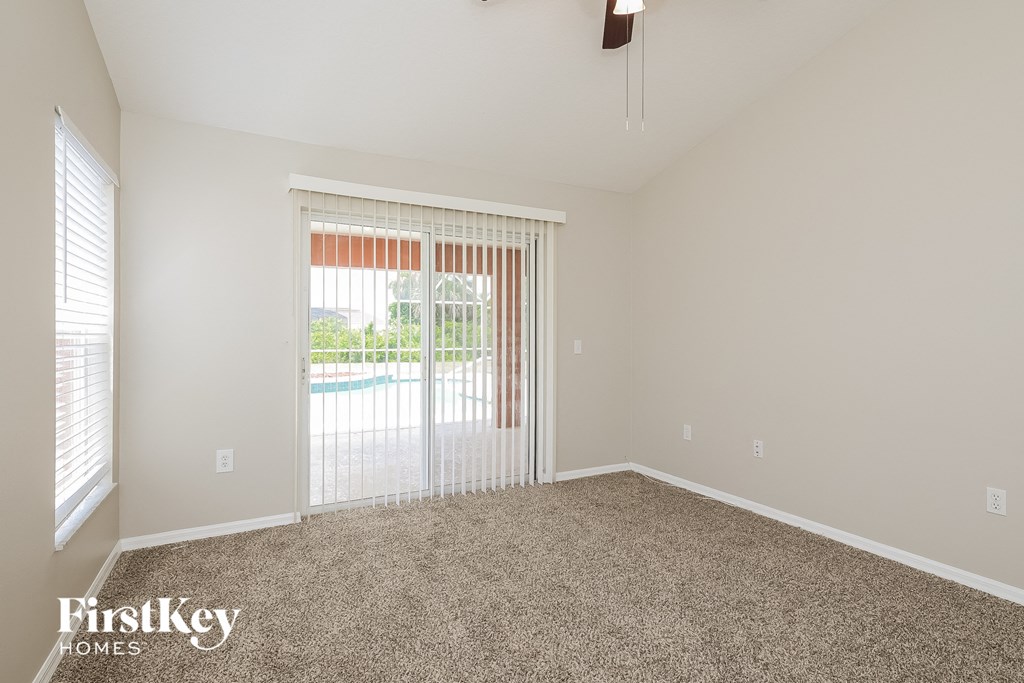 a spacious living room with a sliding glass door to a pool