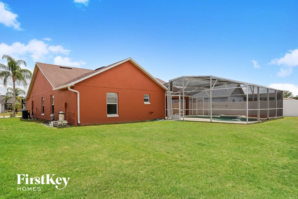 a red house with a greenhouse and a green lawn