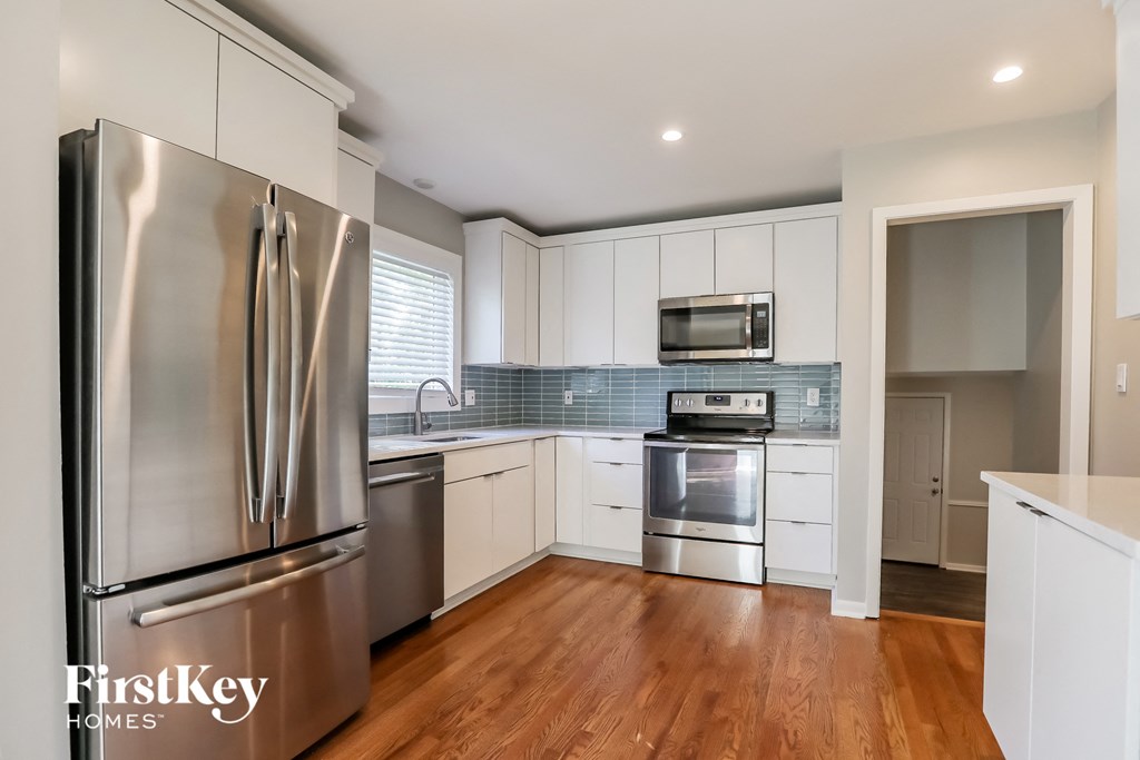 a renovated kitchen with stainless steel appliances and white cabinets