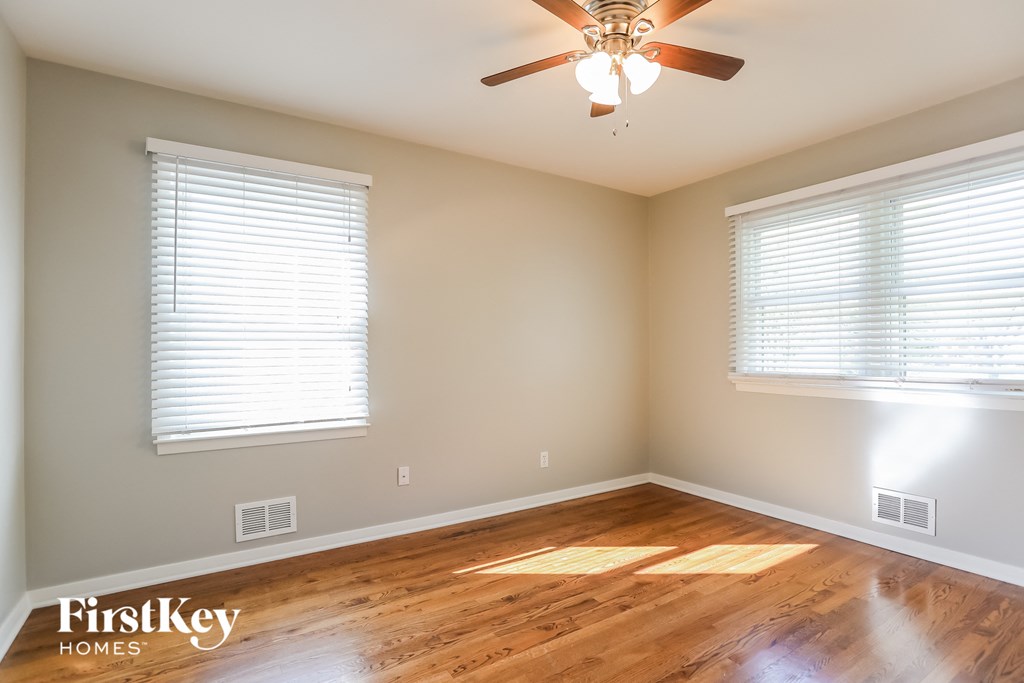 a living room with wood floors and a ceiling fan
