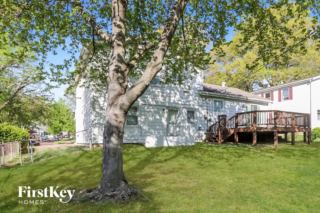 a backyard with a tree and a blue house