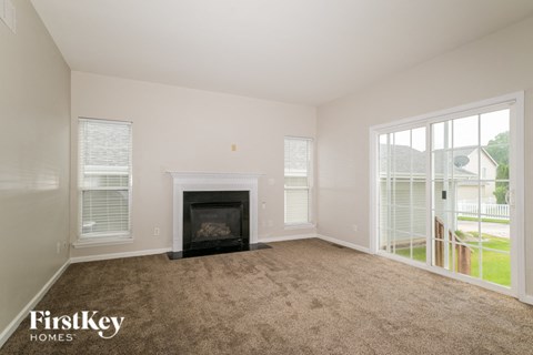 A living room with a fireplace and sliding glass doors.