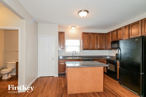 A kitchen with wooden cabinets and black appliances.