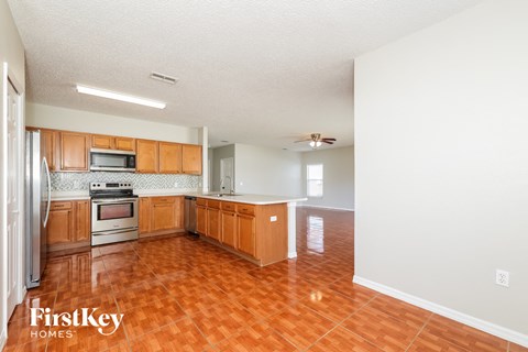A kitchen with wooden cabinets and a tile floor.