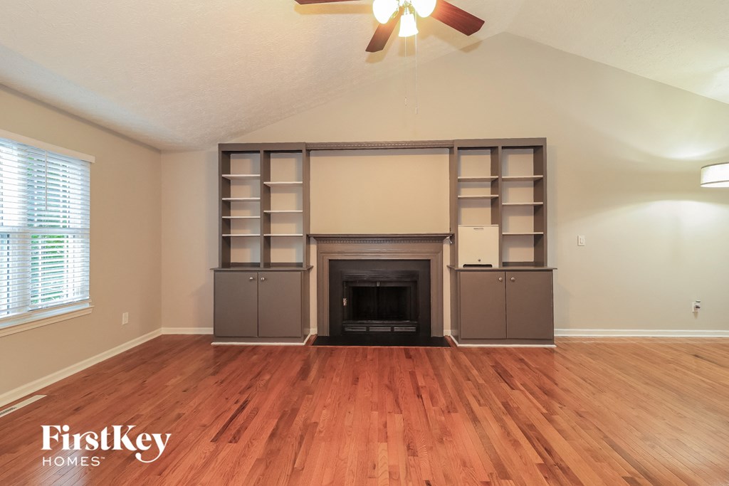 the living room with wood flooring and a fireplace