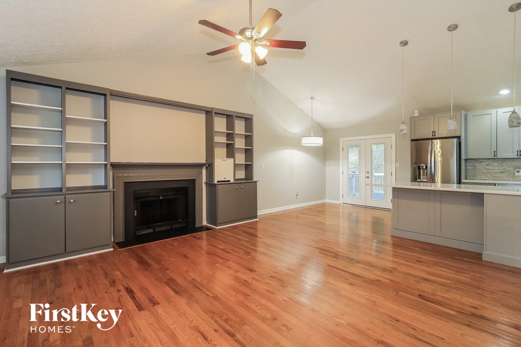 an open living room with a fireplace and wood flooring