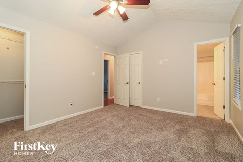 a living room with carpet and a ceiling fan