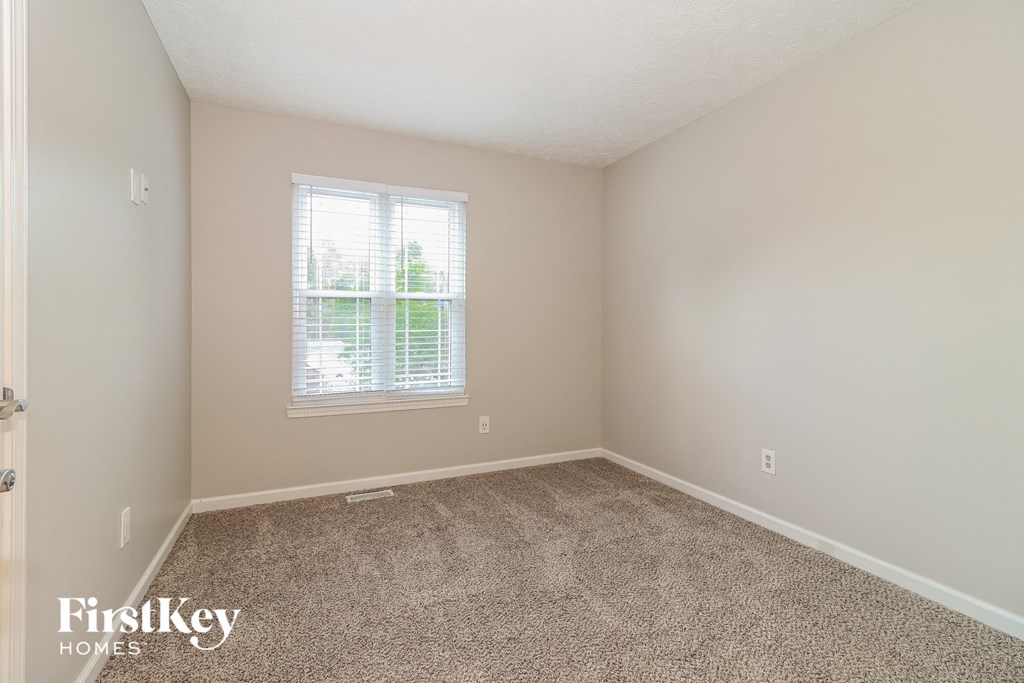 a empty room with carpet and a window