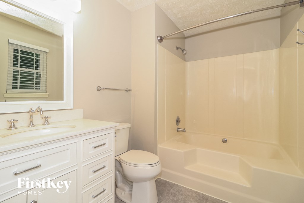 a white bathroom with a tub and a sink and a toilet