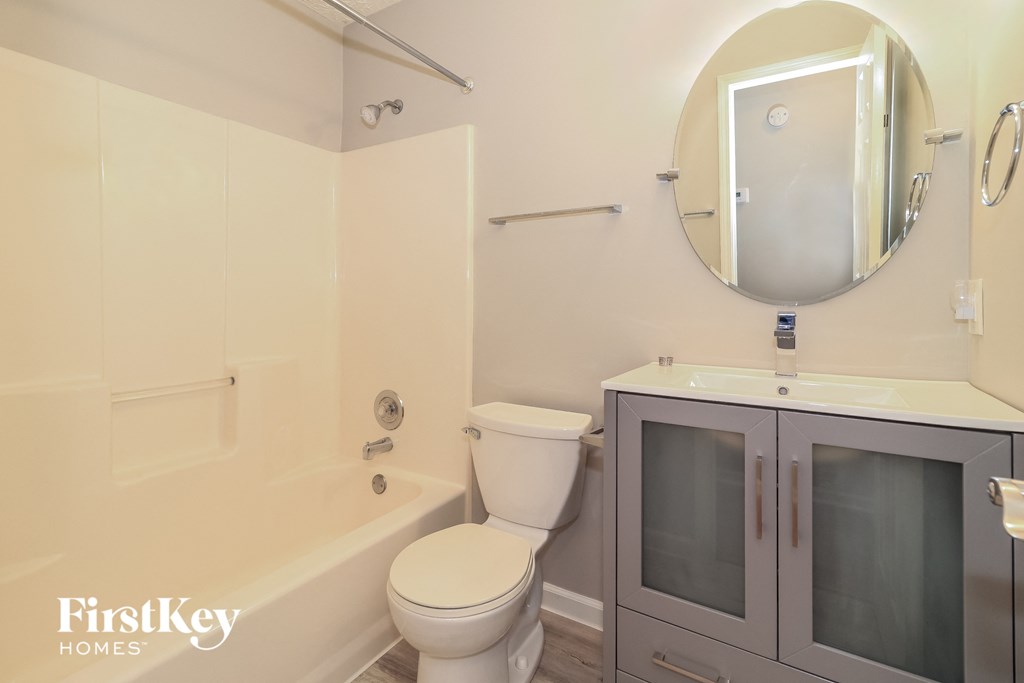 a bathroom with a toilet and a sink and a bath tub
