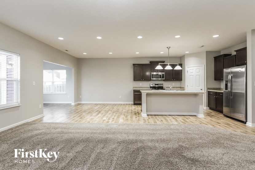 A spacious kitchen with wooden floors and stainless steel appliances.