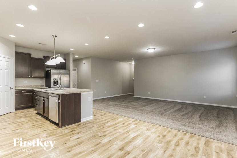A kitchen with wooden floors and a white ceiling.