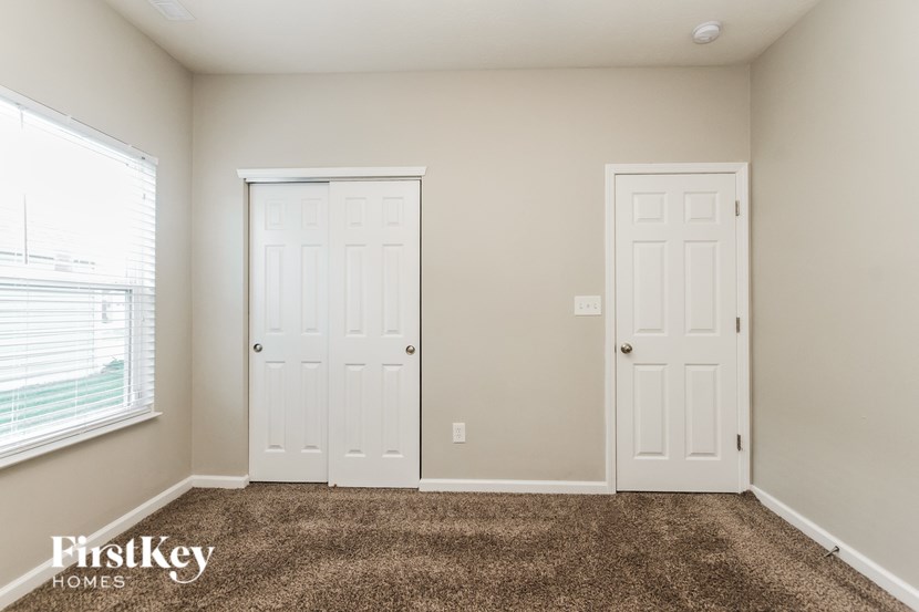 A room with two white doors and a carpeted floor.