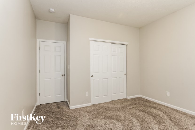 A room with two white doors and a carpeted floor.