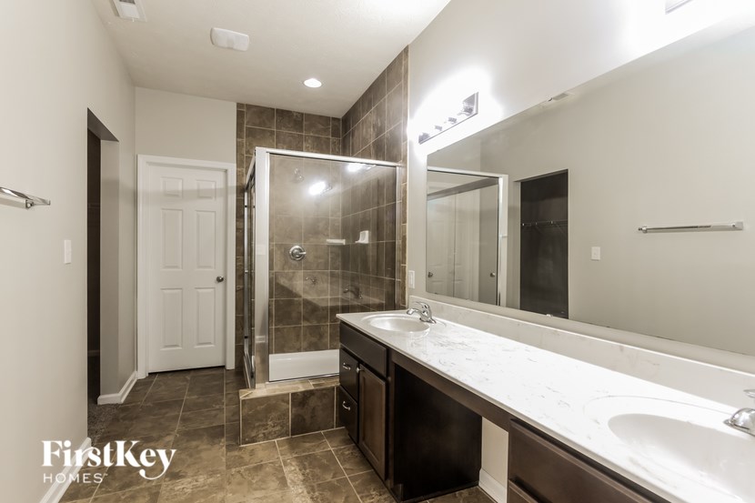 A bathroom with a white sink and a walk-in shower.