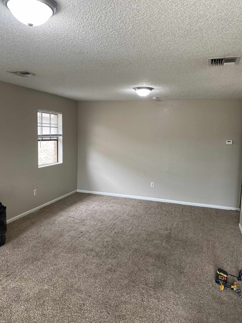 A room with a carpet floor and a window.