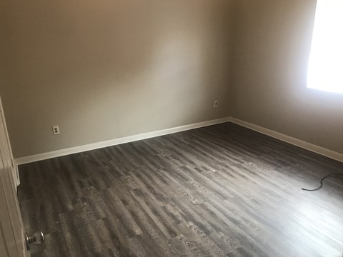 a empty room with wooden floors and a window