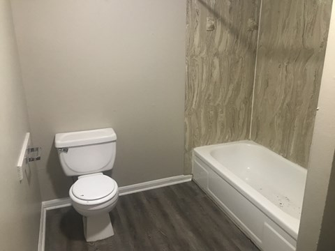 an empty bathroom with a toilet and a bath tub