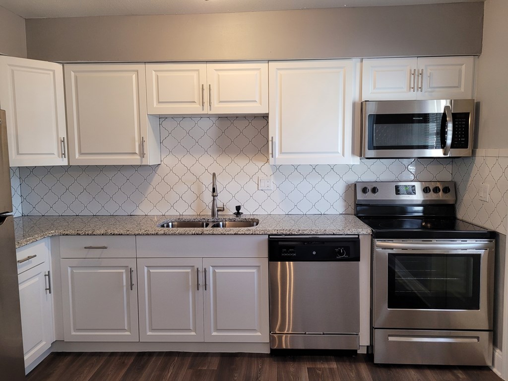 A kitchen with white cabinets and stainless steel appliances.