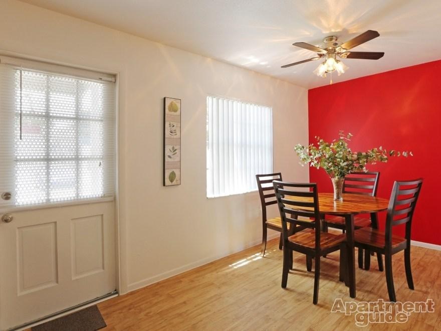 A dining room with a wooden table and chairs.