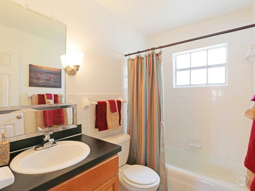 A bathroom with a sink, toilet, and shower.