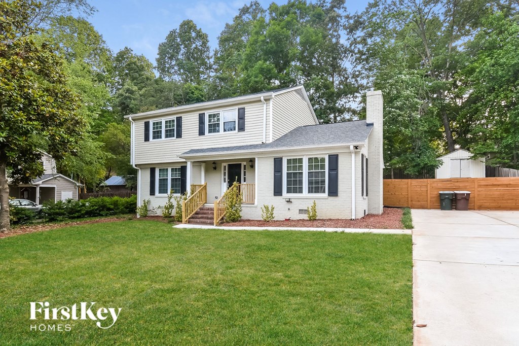 a white house with blue shutters and a lawn
