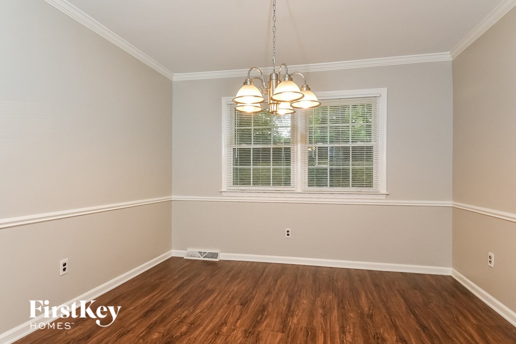 a dining room with hardwood flooring and a window