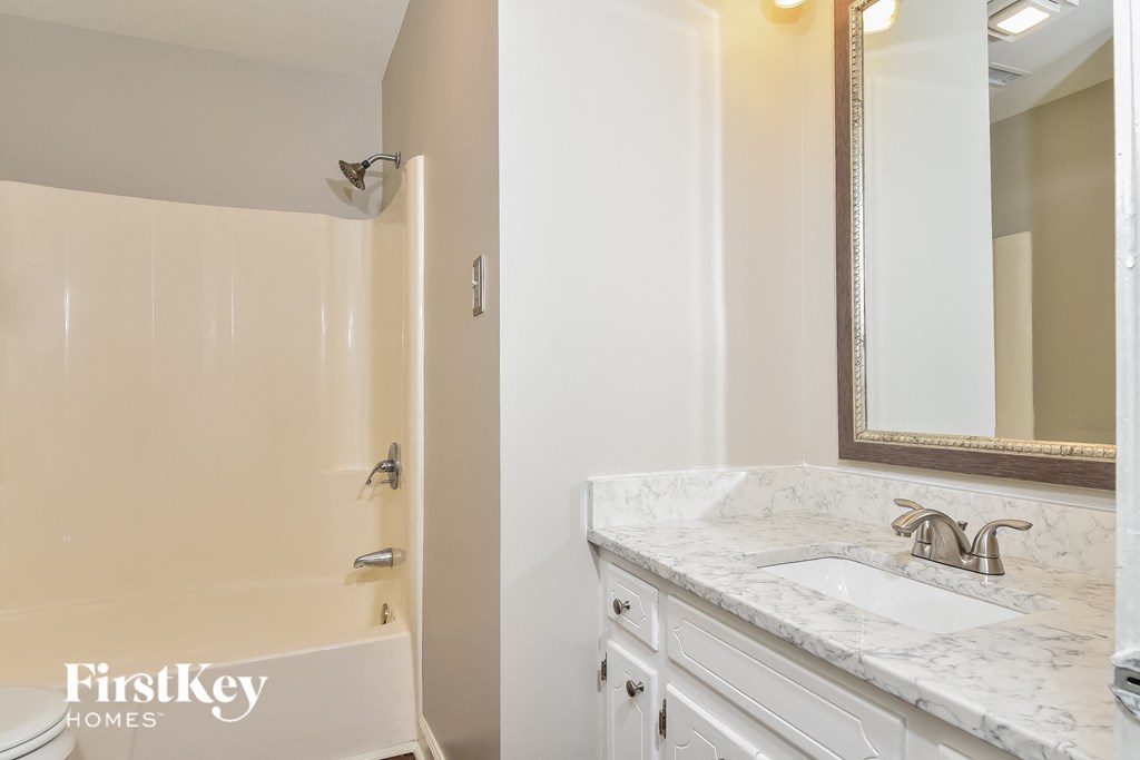 a bathroom with a sink and a shower and a mirror
