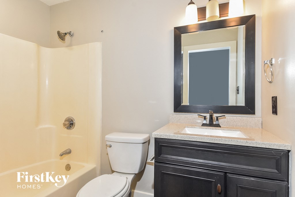 a bathroom with a toilet sink and shower and a mirror