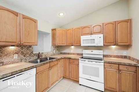 a kitchen with white appliances and wooden cabinets