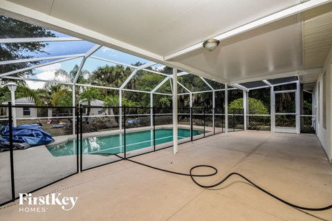 a large patio with a pool in a house with glass doors