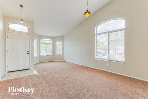 A room with a carpeted floor and a door on the left side.