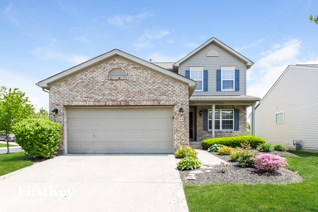 A house with a garage and a driveway in front.