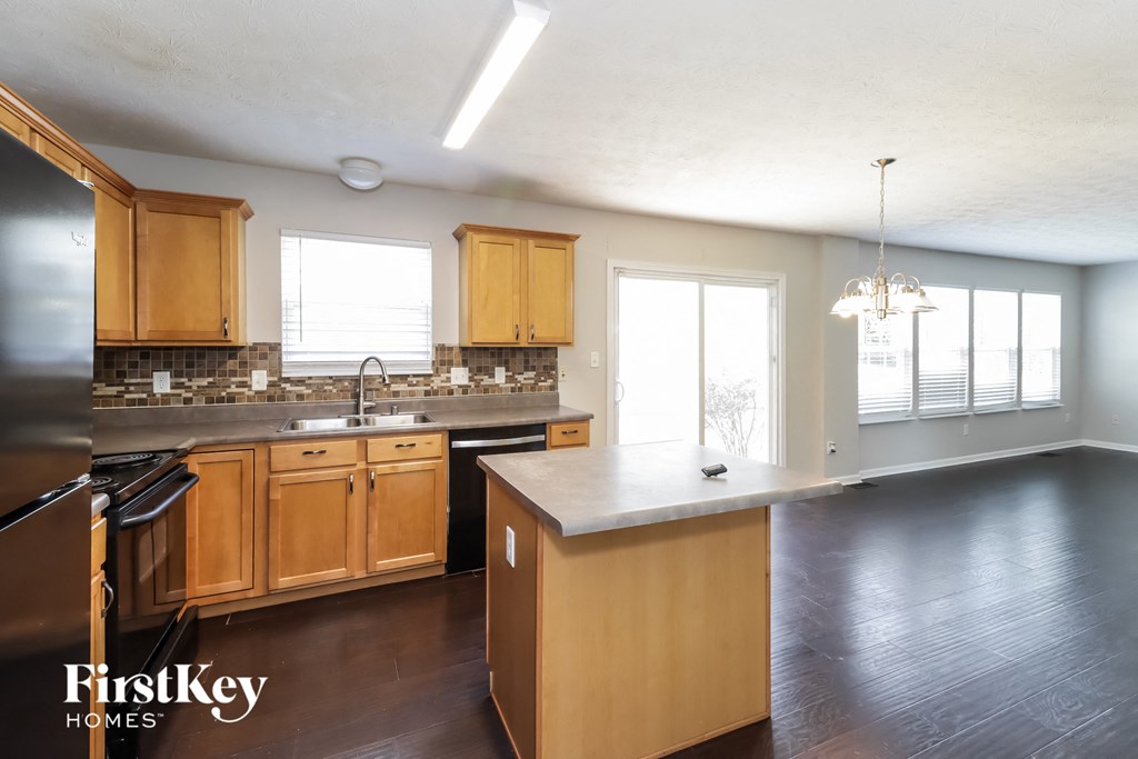 A kitchen with wooden cabinets and a large island.