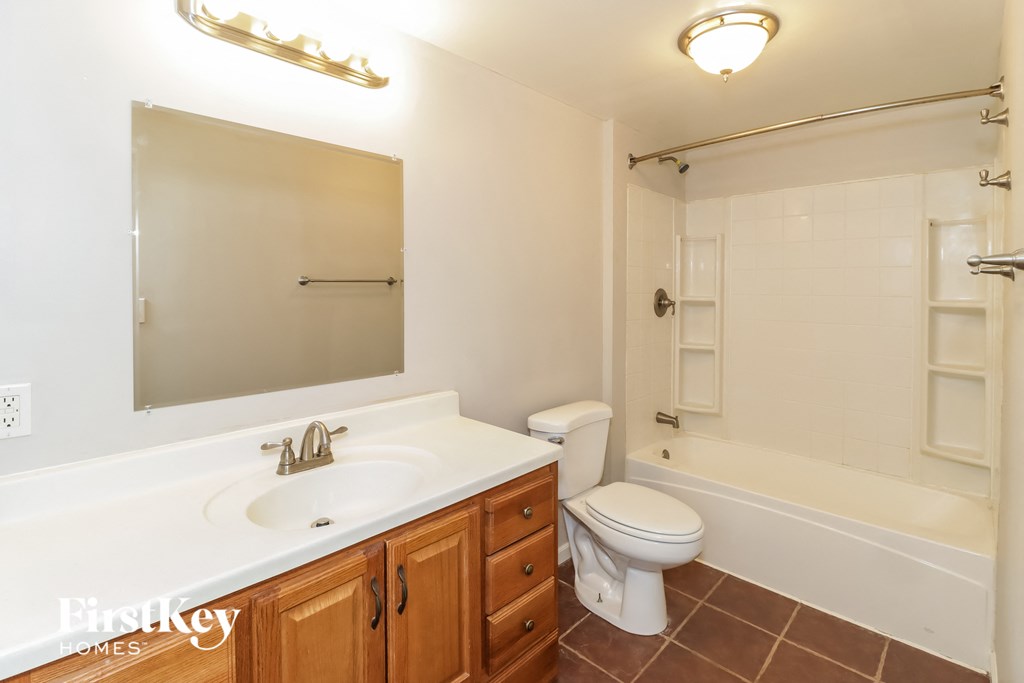 A white bathroom with a sink, toilet and bathtub.