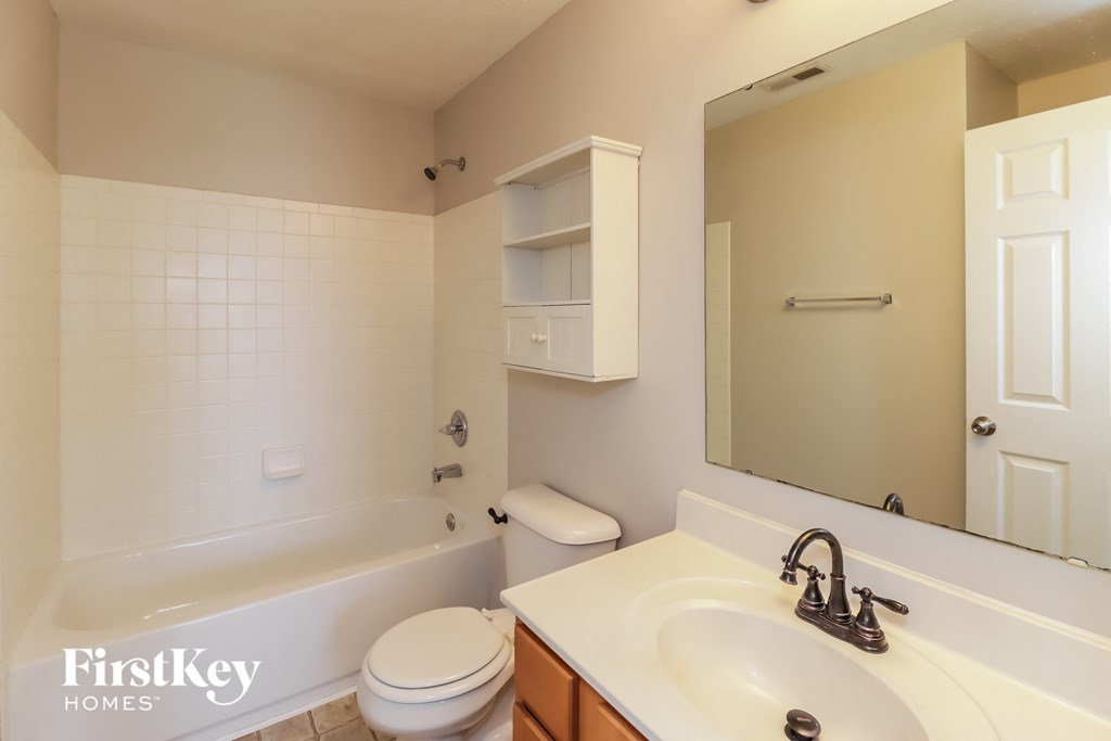 A white bathroom with a toilet, sink, and tub.