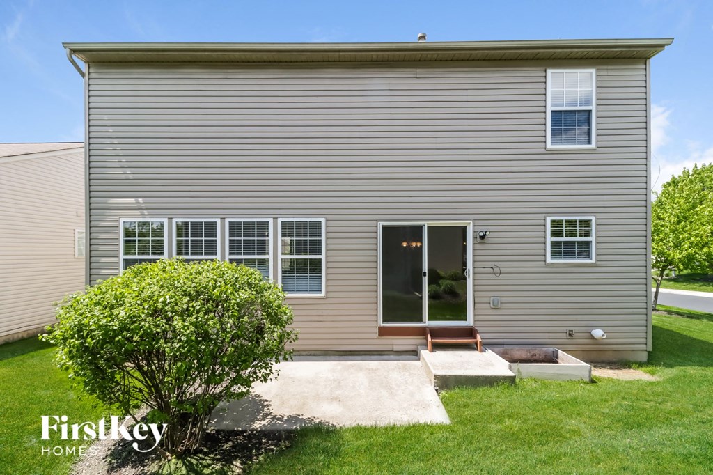 A house with a grey siding and a brown door is shown.