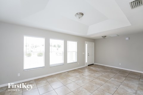 A spacious room with tile flooring and a skylight.