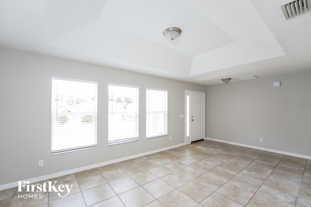 A spacious room with tile flooring and a skylight.